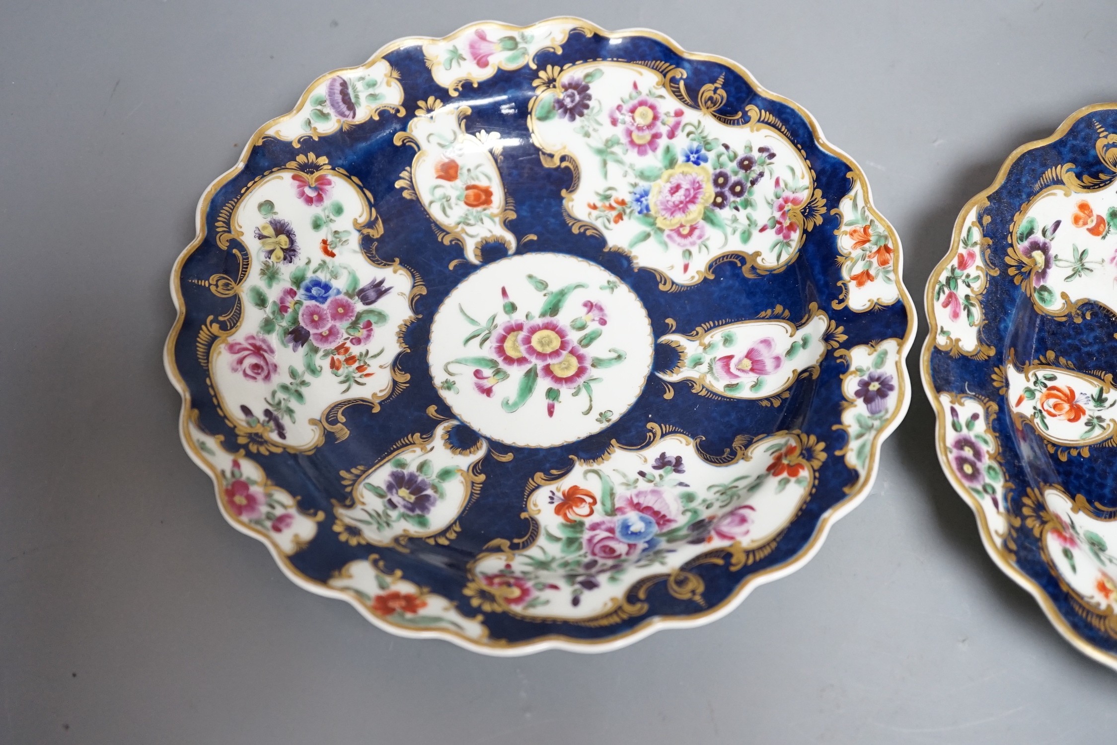 A fine pair of Worcester blue scale plates gilded with mirror like panels, painted with flowers, with fretted square mark, 19cms diameter